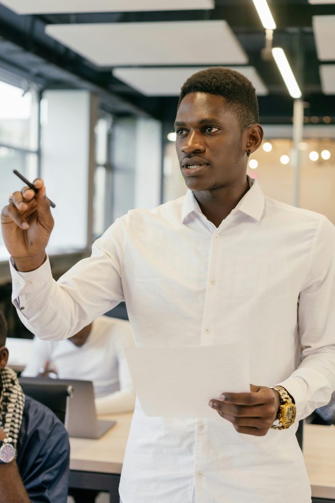 Young African American businessman presenting in a modern office setting.